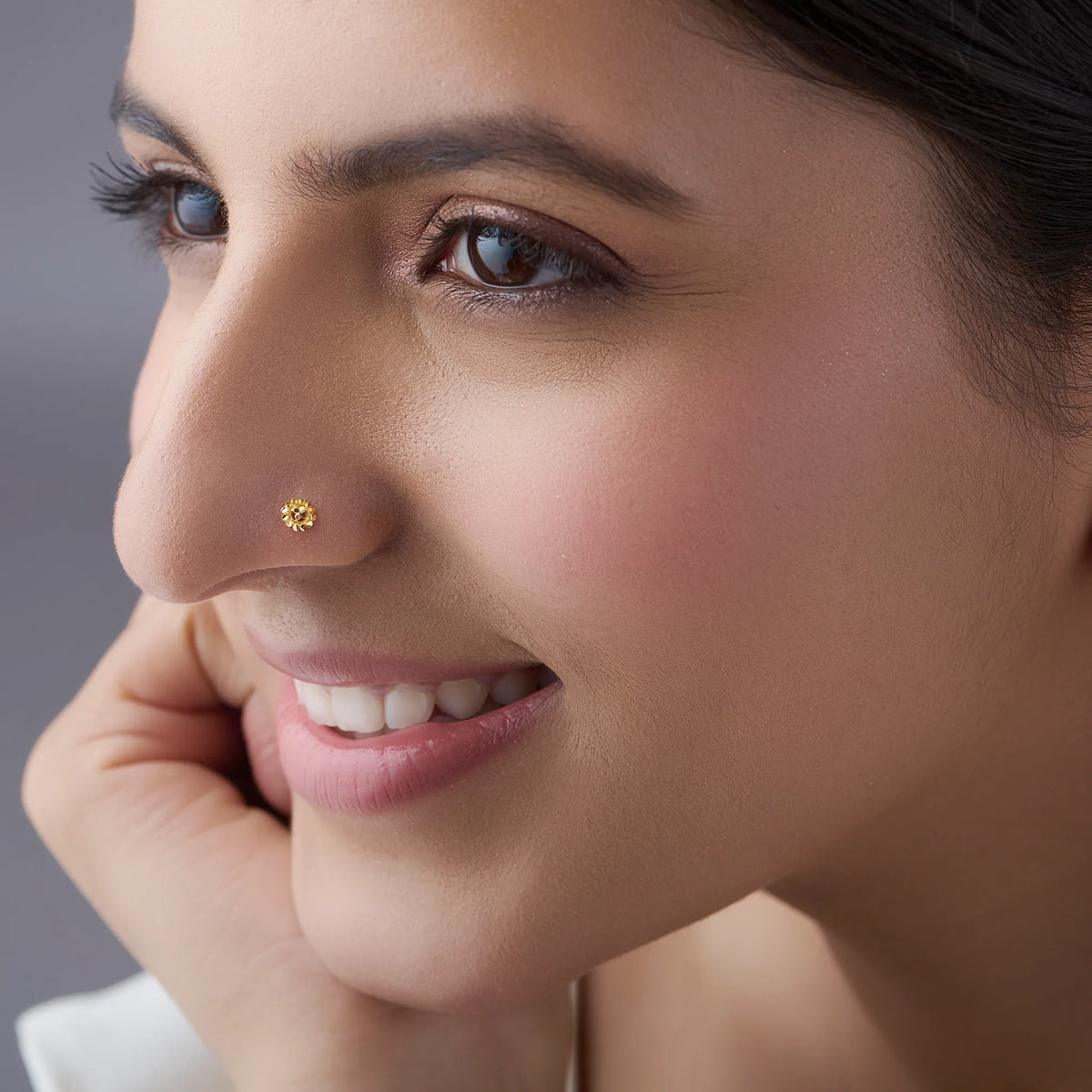 Woman wearing an elegant 18K floral gold nose pin showcasing a subtle everyday look