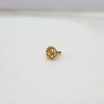 Side view of small 18K floral gold nose pin placed on a white surface displaying its polished finish