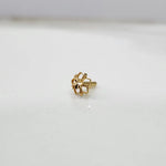 Front view of a tiny 18K gold floral nose pin on a white background showing its fine petal design