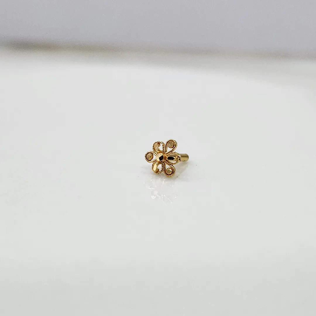 Front view of a small 18K nose pin gold placed on a clean white background highlighting delicate craftsmanship
