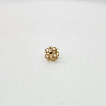 Side view of a tiny 18K nose pin gold on a white surface highlighting its compact size and smooth finish