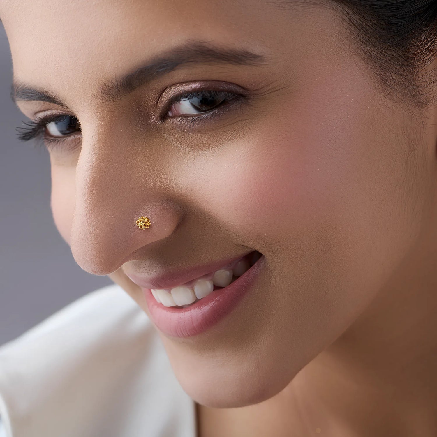 Woman wearing a delicate 18K nose pin gold showcasing an elegant and confident everyday look