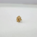 Tiny floral 18K gold nose pin displayed on a white background showcasing its fine craftsmanship