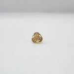 Front view of floral 18K gold nose pin on a white surface emphasizing the compact and symmetrical design