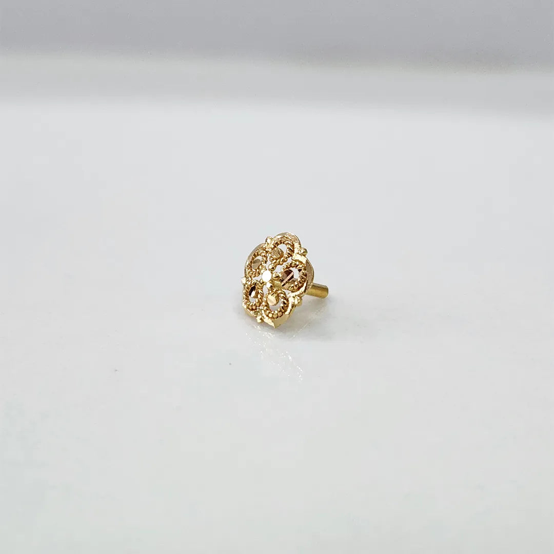 Small floral 18K nose pin gold on a white background showing its delicate detailing
