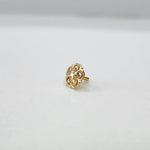 Small floral 18K nose pin gold on a white background showing its delicate detailing
