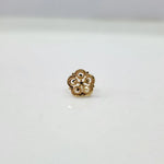 Close-up of floral 18K nose pin gold on a clean surface highlighting its intricate design