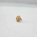 Side angle view of petite floral gold nose pin on a white surface emphasizing its lightweight and compact profile