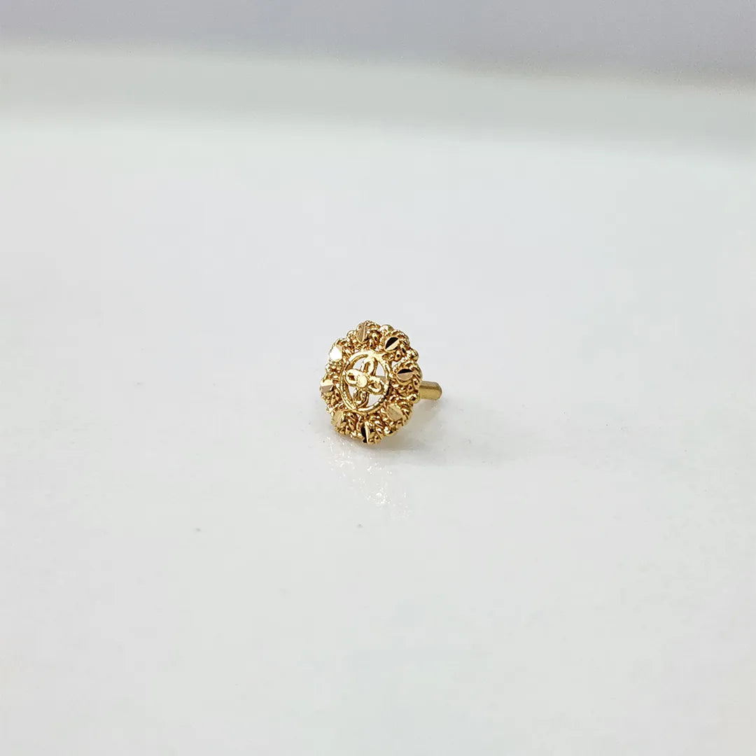 Side angled view of floral gold nose pin on a white surface highlighting compact size and delicate structure