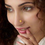 Woman wearing a floral gold nose pin showing elegant traditional inspired styling on the face