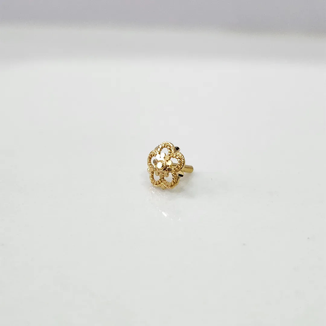 Side view of the floral gold nose pin on a white surface highlighting its compact size and neat finish
