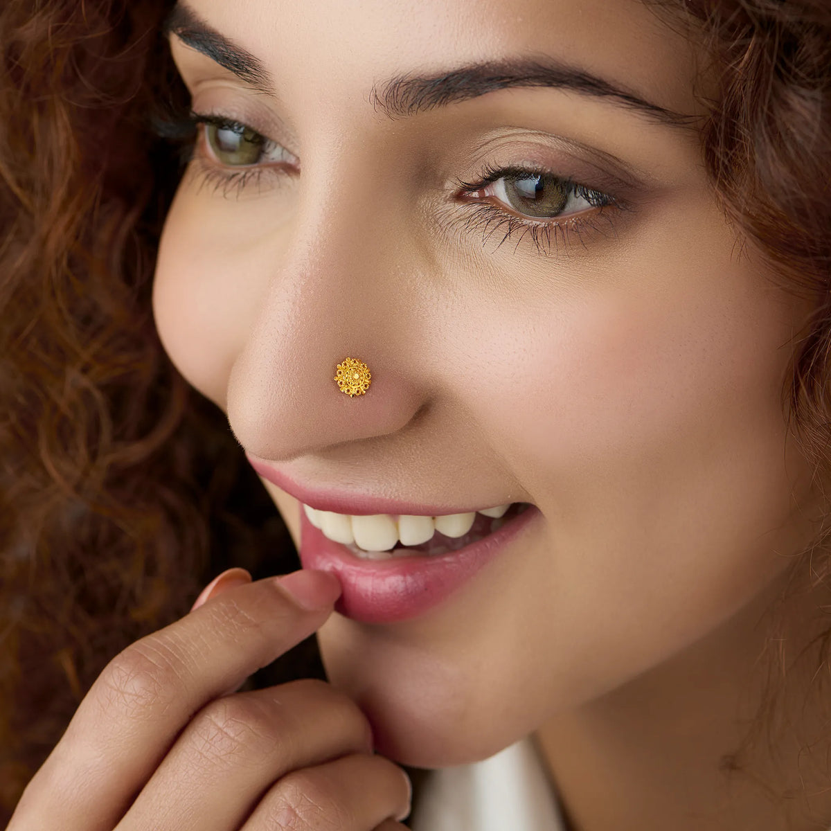 Woman wearing a floral gold nose pin showcasing a graceful everyday look with traditional elegance