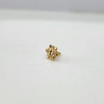 Close-up of tiny floral 18K nose pin gold on a clean white background displaying intricate design