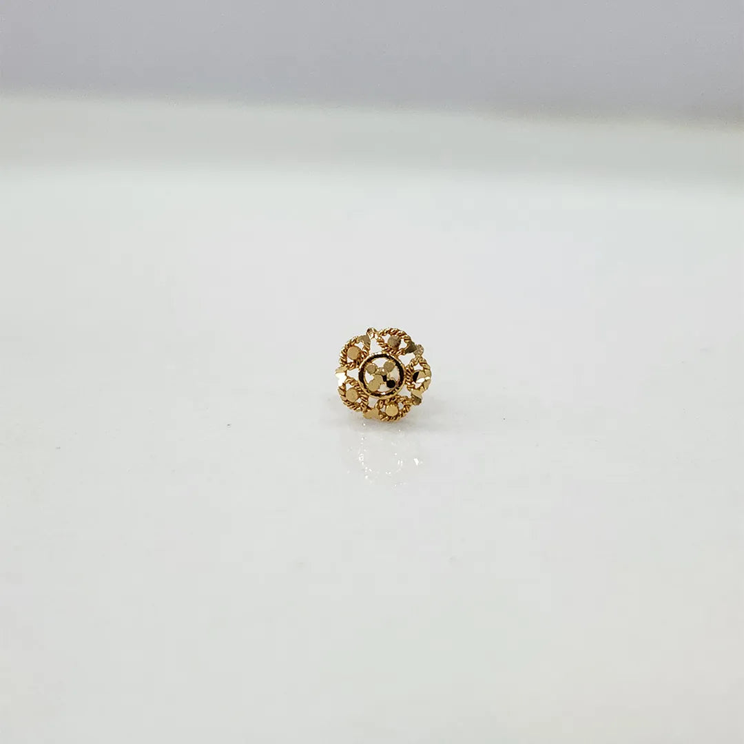 Front view of a small floral gold nose pin placed on a white background showing compact size and fine detailing