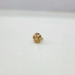 Side view of the floral gold nose pin on a white surface highlighting its depth and polished finish