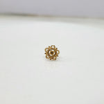 Close up of handcrafted floral gold nose pin design on white background elegant and minimal style