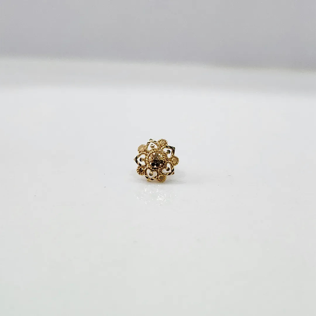 Close-up of floral 18K nose pin gold on a clean white surface highlighting its polished finish