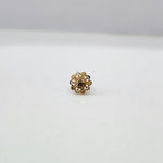 Close-up of floral 18K nose pin gold on a clean white surface highlighting its polished finish