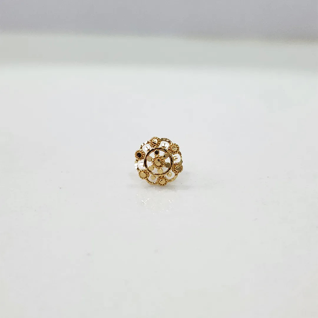 Side view of floral gold nose pin on a white surface showing compact size and detailing
