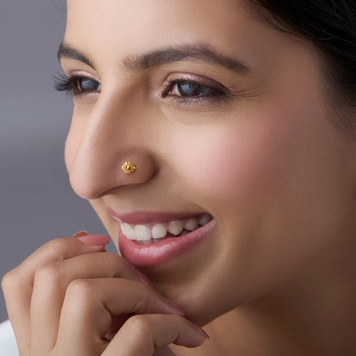 Woman wearing a floral 18K gold nose pin showcasing elegant everyday Indian jewellery styling