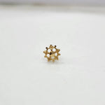 Close-up of tiny floral 18K nose pin gold on a clean white background highlighting fine detailing