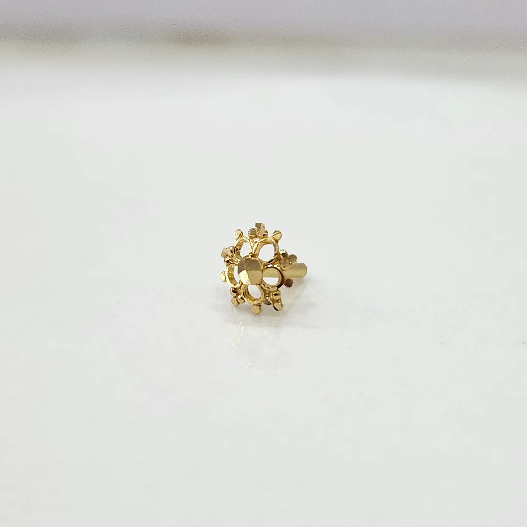 Small floral 18K nose pin gold displayed on a white surface showing delicate craftsmanship