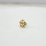 Small floral 18K nose pin gold displayed on a white surface showing delicate craftsmanship
