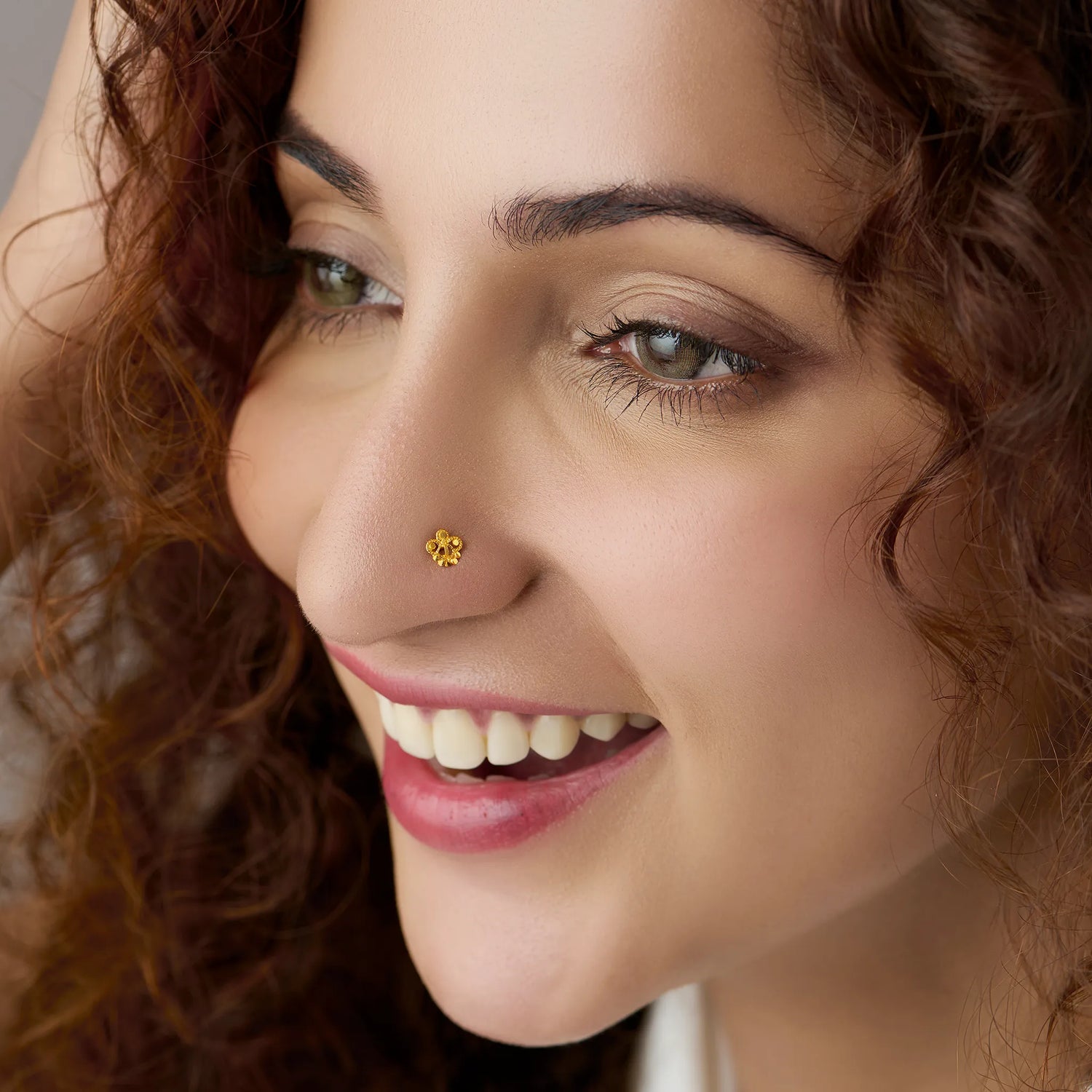 Woman wearing floral 18K nose pin gold showcasing an elegant and natural everyday look