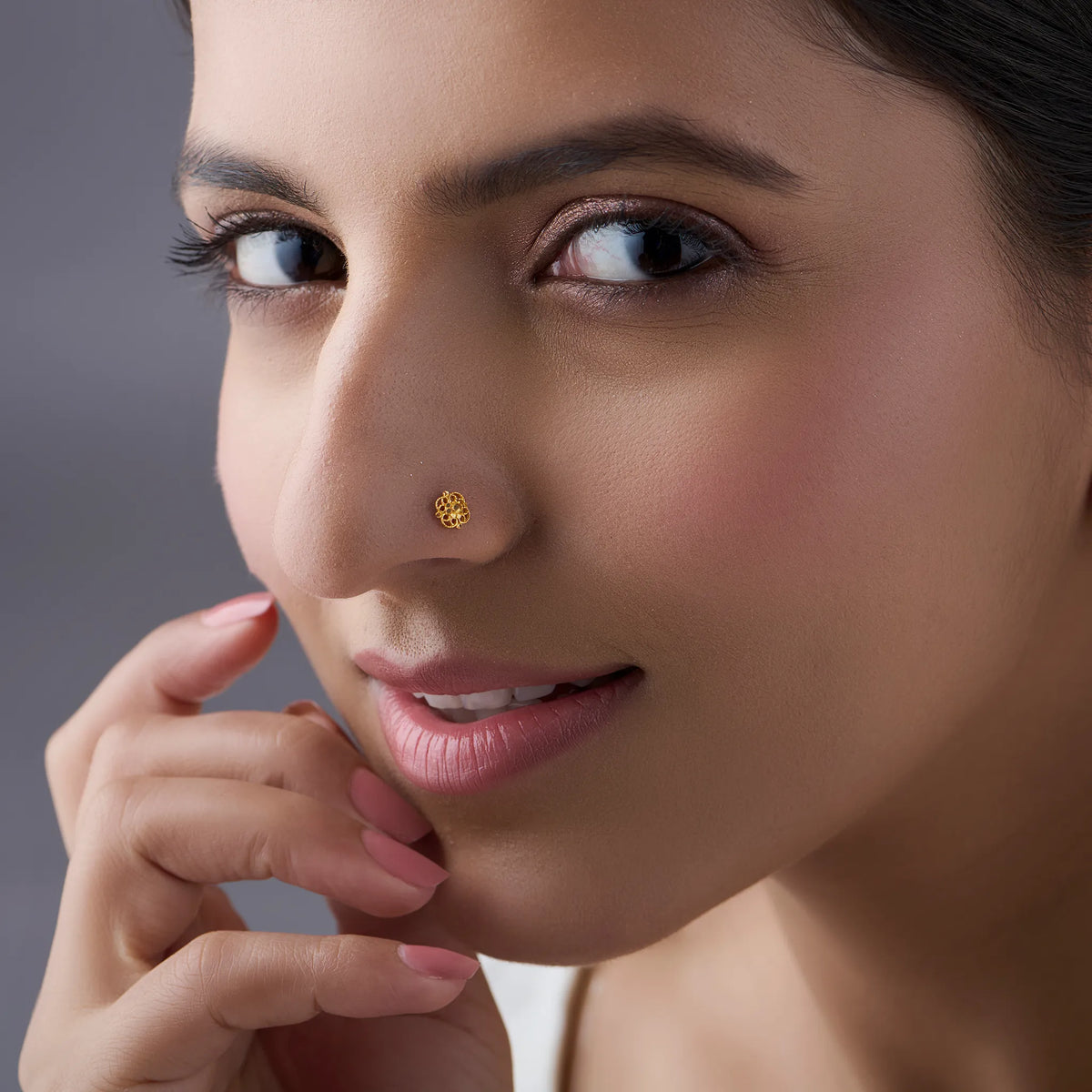 Woman wearing a delicate 18K gold nose pin showcasing an elegant and minimal everyday look