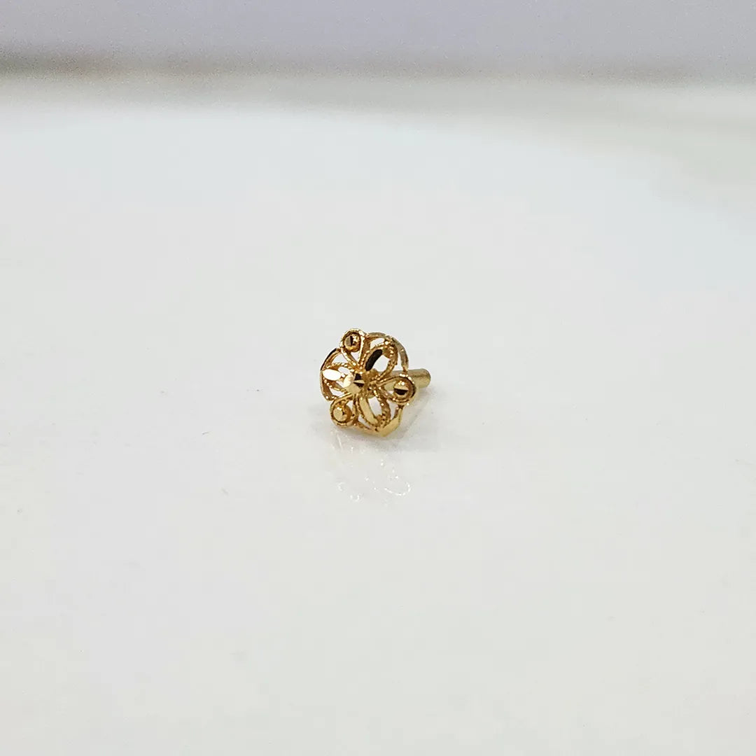 Front view of small floral 18K gold nose pin on a white background showing fine detailing