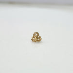 Front view of a tiny floral gold nose pin placed on a white background showing precise detailing and compact size
