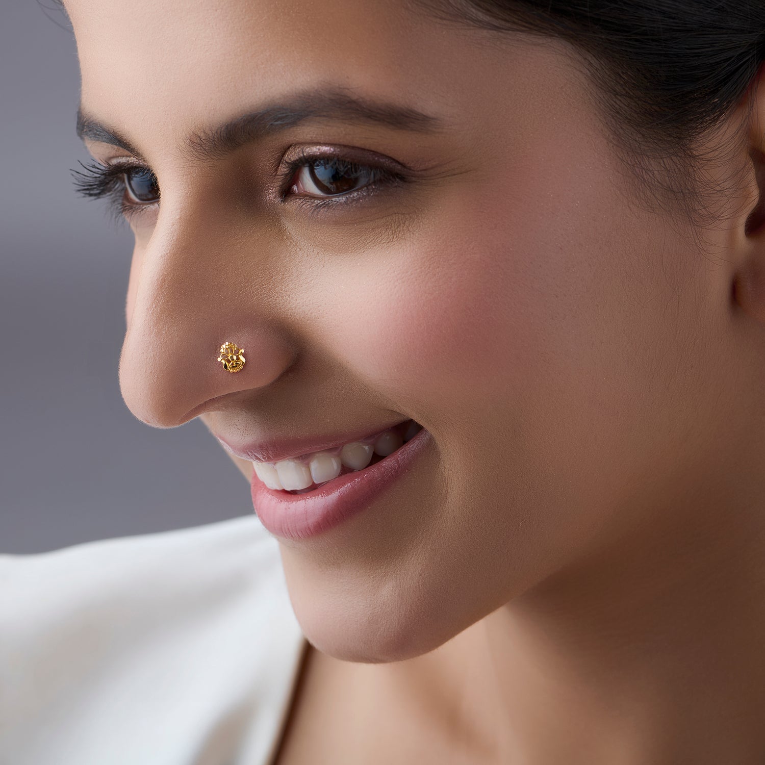 Woman wearing a small gold nose pin showcasing a soft smile and elegant everyday look