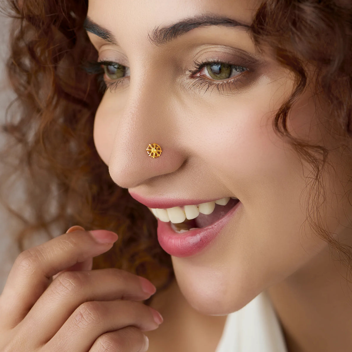 Woman wearing a delicate floral 18K gold nose pin showcasing its elegant and minimal design