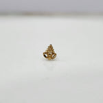 Side view of small 18K gold nose pin placed on a white surface showing its polished finish