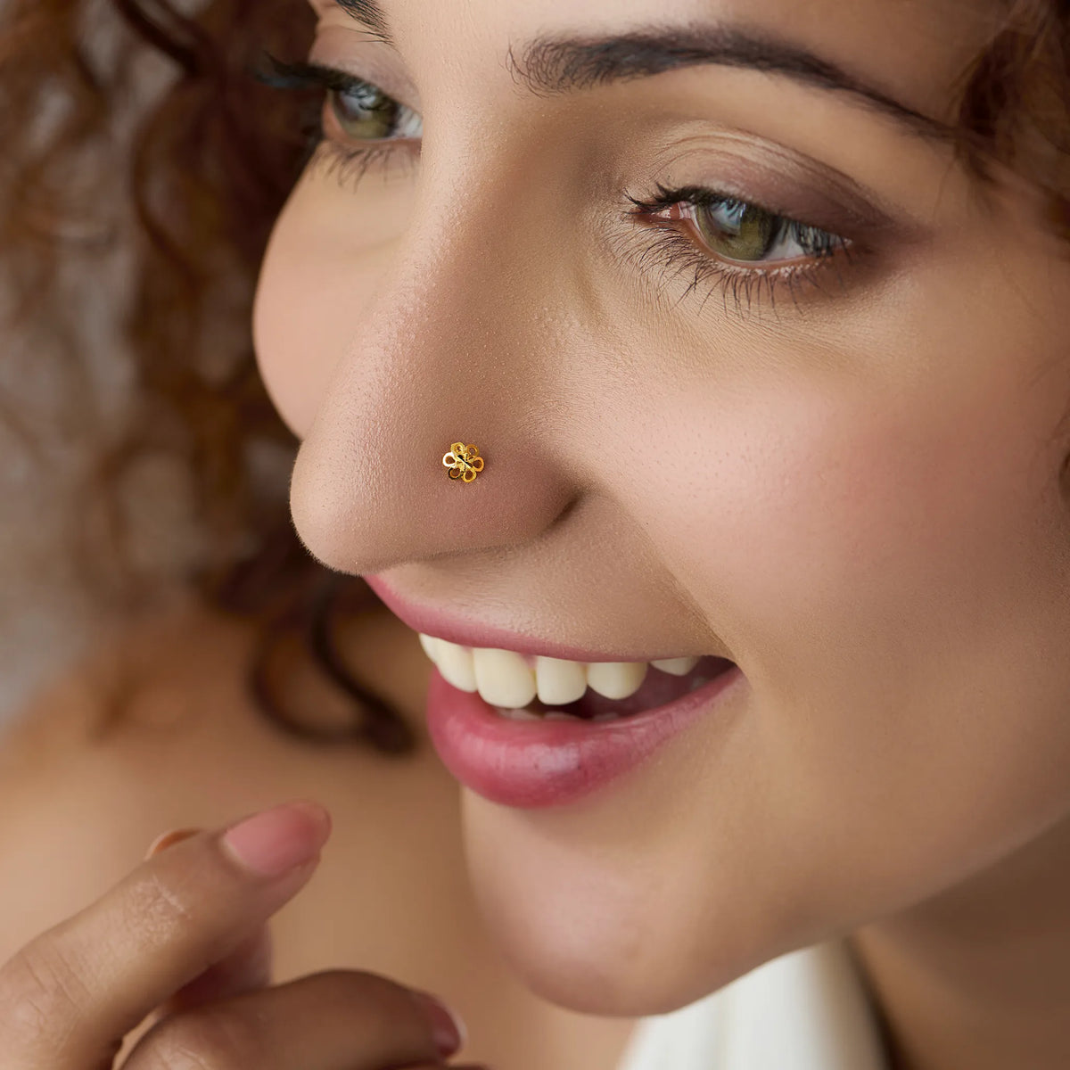 Woman wearing a small floral gold nose pin showcasing a natural elegant look