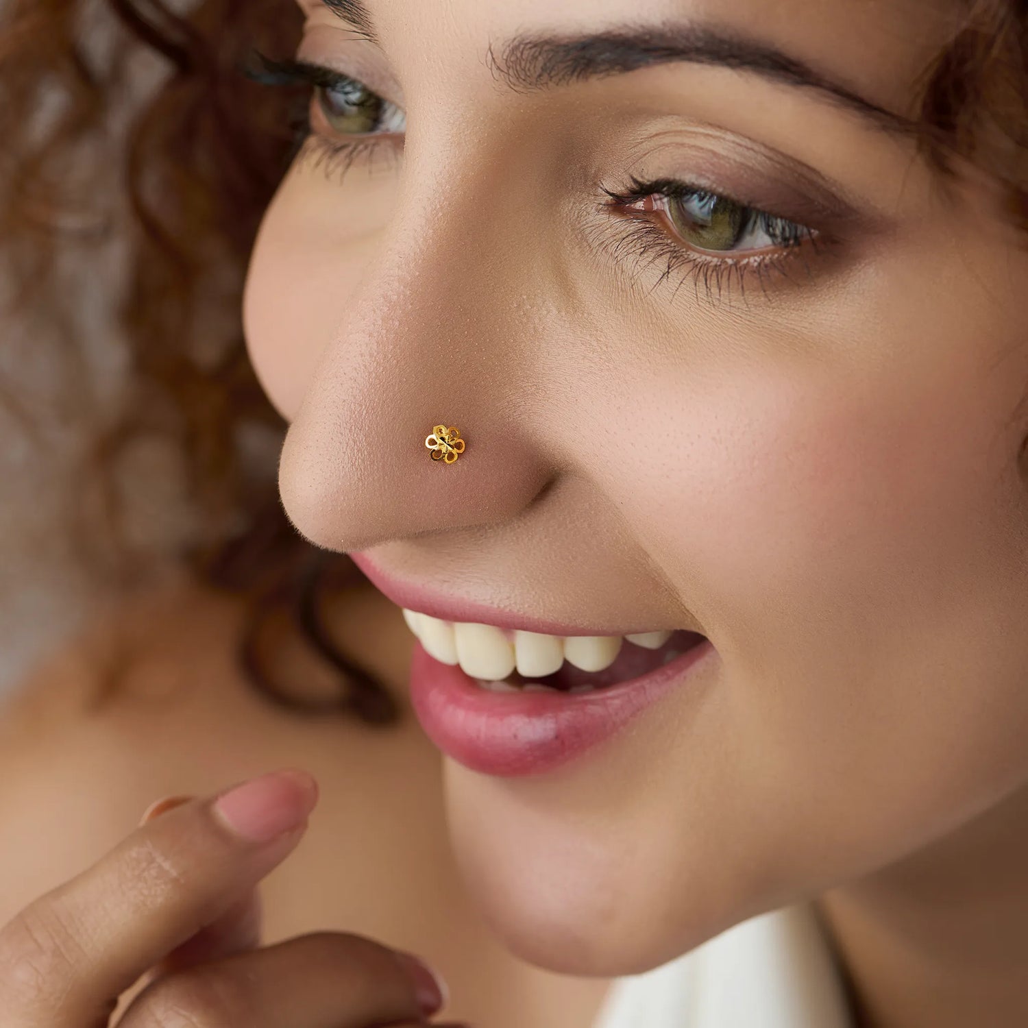 Woman wearing a small floral gold nose pin showcasing a natural elegant look
