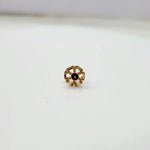 Side view of small floral 18K nose pin gold with red stone captured on a white background highlighting its polished finish