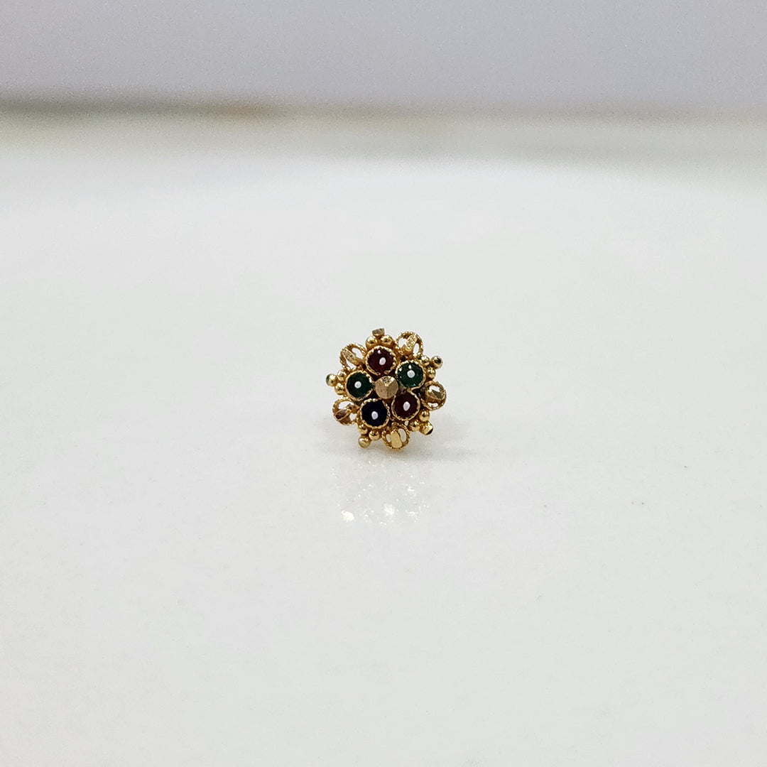 Front view of floral gold nose pin with green stones on a clean white surface