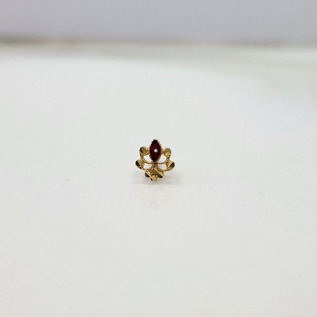 Small 18K gold floral nose pin captured on a white background showing its polished finish