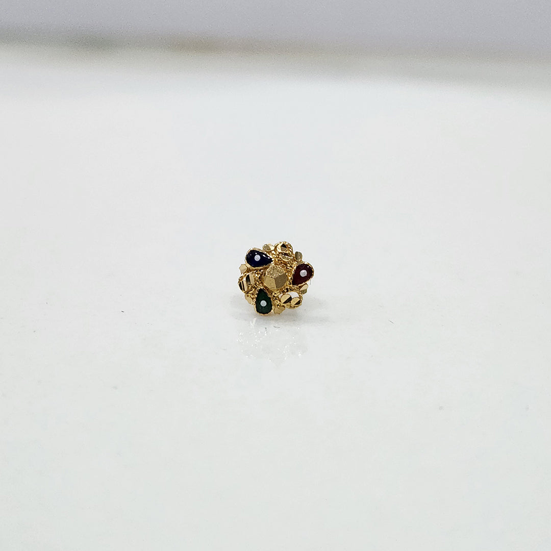 Close-up of tiny floral 18K nose pin gold on a clean white background showing fine craftsmanship
