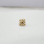 Close-up of small 18K nose pin gold showing its intricate geometric design on a clean surface