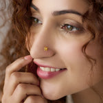 Woman wearing a delicate 18K gold nose pin showcasing an elegant everyday look