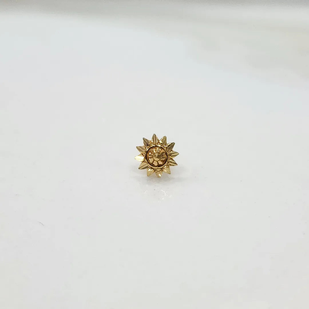 Small sun-design 18K nose pin gold captured on a clean background showing fine detailing