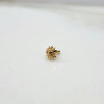 Tiny sun motif 18K nose pin gold on a white surface highlighting its delicate finish