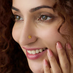 Woman wearing a delicate floral gold nose pin showing a soft everyday styling look