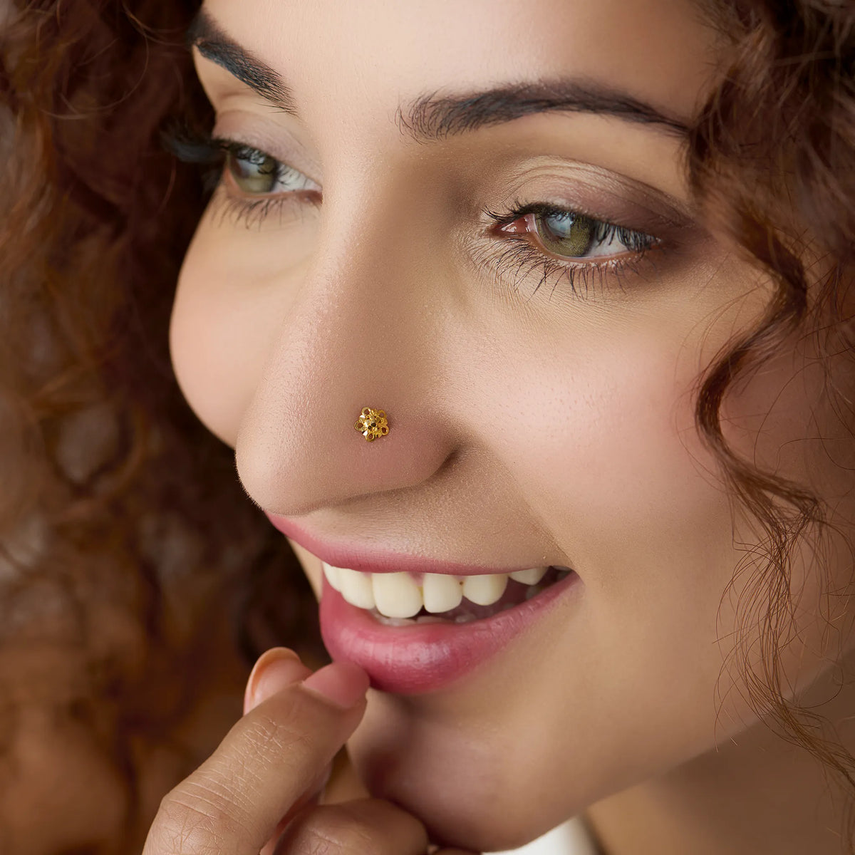 Woman wearing a delicate floral gold nose pin showcasing a refined and elegant everyday look
