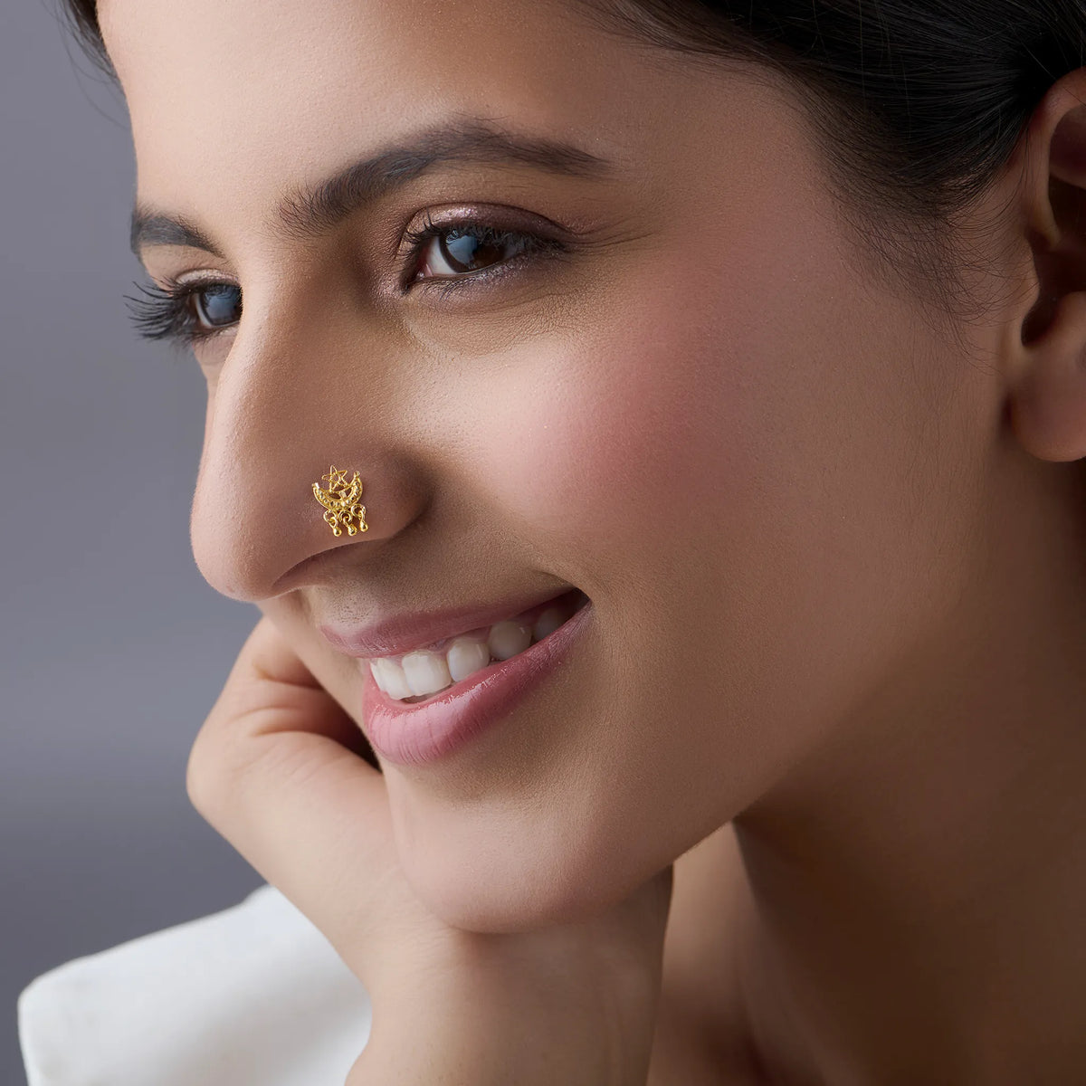 Woman wearing elegant maharashtrian gold nose pin showcasing cultural crescent design and intricate detailing