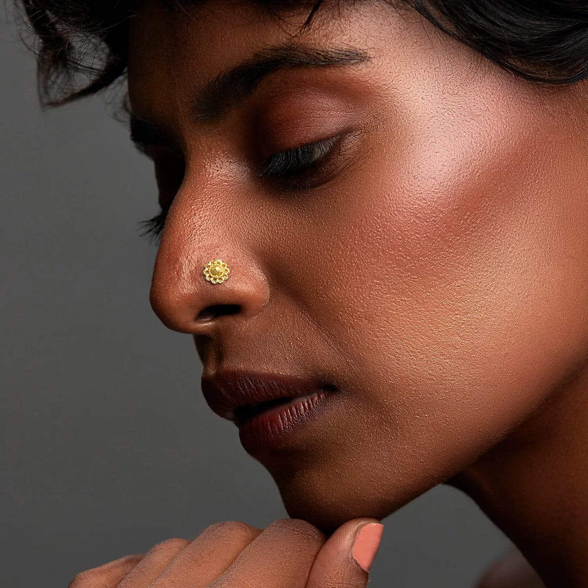 Woman wearing a delicate 18K nose pin gold in side profile showcasing an elegant minimal everyday look