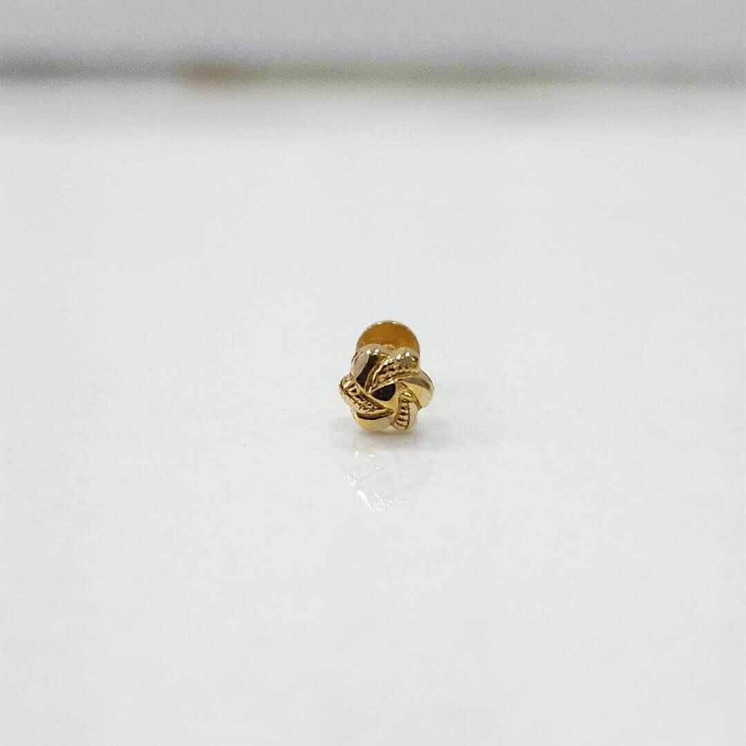 Close-up view of knot motif 18K nose pin gold on a white background showing fine handcrafted detailing