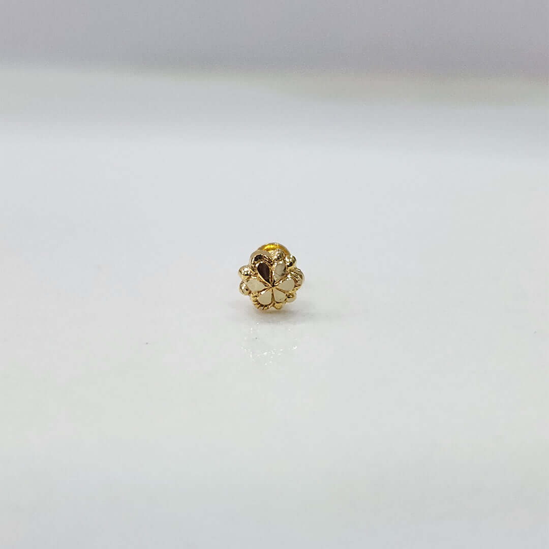 Side view of delicate 18K nose pin gold capturing its polished finish on a clean surface